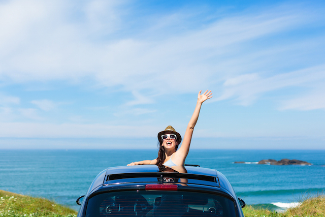 Woman on car vacation travel waving
